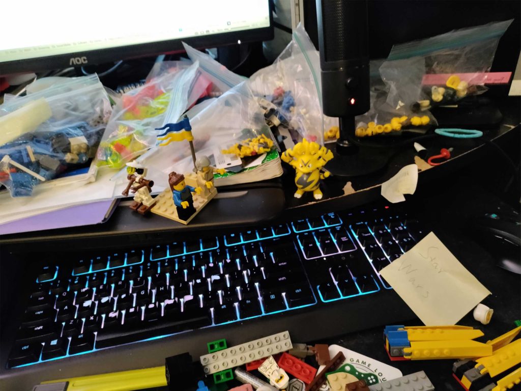Picture of my computer desk, littered with Lego parts.